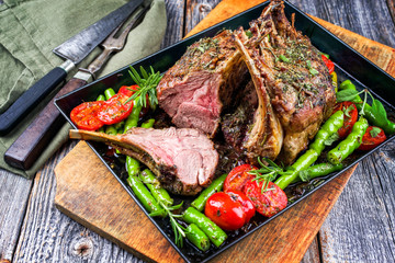 Barbecue rack of lamb neck with paprika and tomato offered as closeup on a metal tray