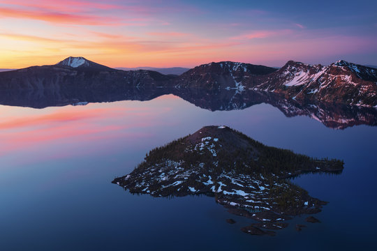 volcanic lake in mountains at sunrise with colorful reflection