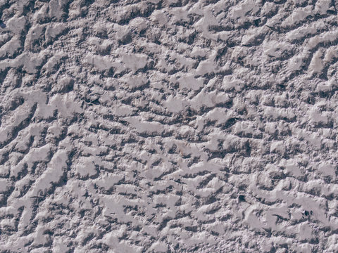 The pattern of light gray grooved shiny wall. Shades of grey with silver tones backdrop. Monochrome textured backdrop. Ancient wall structure closeup. Abstract raggy silver background.