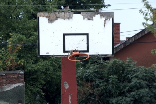abandoned basketball court with broken hoop and board