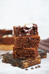 Delicious brownie chocolate cakes poured with warm chocolate and decorated with almond petals. Vertical orientation