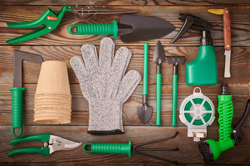 Gardening tools on wooden background flat lay top view