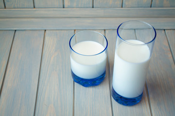 Glass of milk on wooden table, blue and white style, copy space