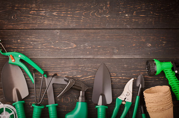Gardening tools on wooden background flat lay top view