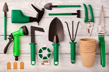 Gardening tools on wooden background flat lay top view