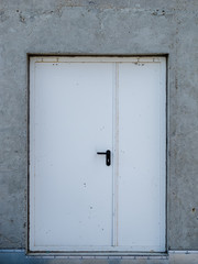 iron white metal door in concrete wall, front view