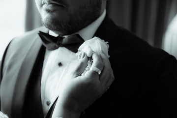 Handsome stylish groom with beard and mustache getting dressed and preparing for the wedding day