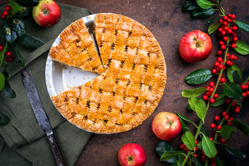 Traditional apple jalousie cake offered as top view in a backing form with decoration on a black...