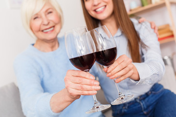 Toast of health! Old mother and daughter drinking wine