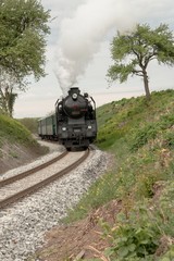 A steam passenger train arrives
