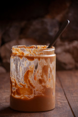 Jar of peanut butter on rustic wooden table and stone background.Vertical with copyspace.