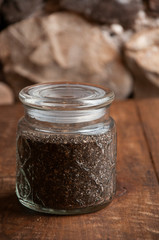 jar full of chia on the rustic wooden table. Vertical with copyspace.
