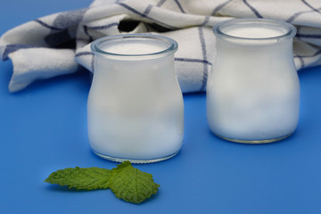 Tubs of natural yogurt, derived from cow's milk.