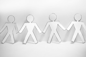 Paper people on green grass, close up