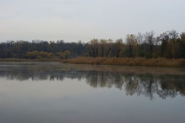 Landscape view of a lake with pipes of a large plant in the background
