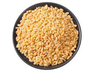 wheat grains in a black plate isolated on white background. top view