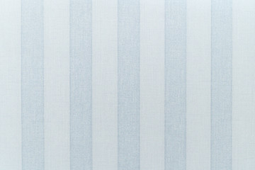 Papier peint sur le mur avec la texture du lin. Large papier peint à rayures verticales gris-bleu. La texture du papier peint est en lin.