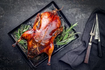 Wall murals Beijing Traditional roasted stuffed Christmas Peking duck with herbs as top view on a rustic board with copy space