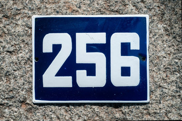 Weathered grunge square metal enameled plate of number of street address with number 256 closeup