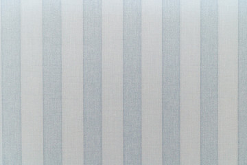 Paper Wallpaper on the wall with the texture of linen. Wide Vertical gray-blue stripes Wallpaper. The texture of the Wallpaper is linen.