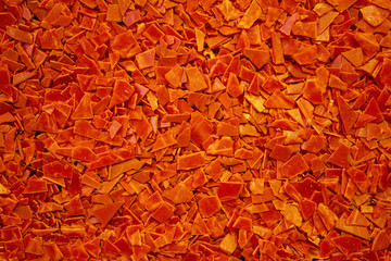 Shards of red flat plastic lying in bulk on the surface..