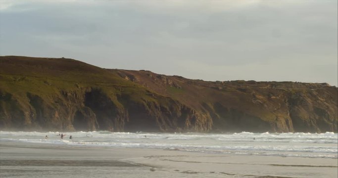 Perranporth sands beach, Cornwall, England with waves breaking fast on shore, panning shot.