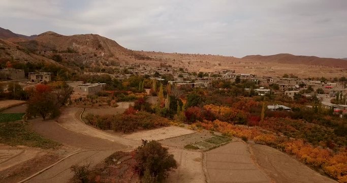 A mountain village with saffron farm fields in autumn leaves colorful trees forest and stair shape village town in mountain landscape in Iran in sunset time