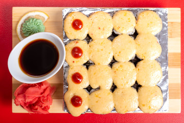 A large set of baked rolls with cheese caps.