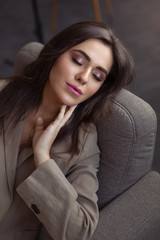 Fototapeta premium Sensual girl with closed eyes sits in a chair