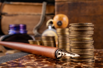 Coins arranged in bars on an old book. An accountant's workplace in an old company.