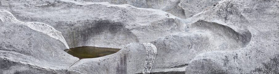 Beautiful rock layers in a granite stone formed by water.