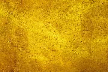 Roughly plastered wall texture background painted with gold paint