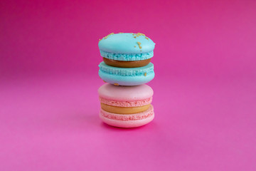 Macarons with cream in pastel colors on pink background. Close up view and copy space. 