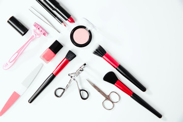 Top view on set of woman make up cosmetics on white background. Beauty and fashion concept. On table lies lipstick, eye pencil, eye shadow, brushes. Fashionable Women's Cosmetics and Accessories.