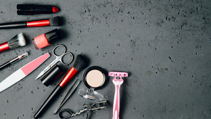 Top view on set of woman make up cosmetics on dark, stone table. Beauty and fashion concept. On...