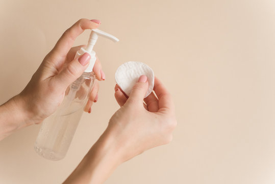 The girl pours micellar gel on a cotton pad to cleanse the skin. The girl's hands squeeze out micellar water on a cotton pad
