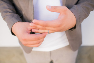 A man removes a wedding ring from a finger of his hand. Bad relationship with his wife. Divorce couples.