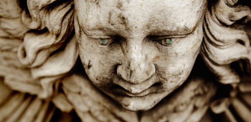 Death. Close up sad face of angel as symbol of pain, fear and end of life. Ancient sculpture.