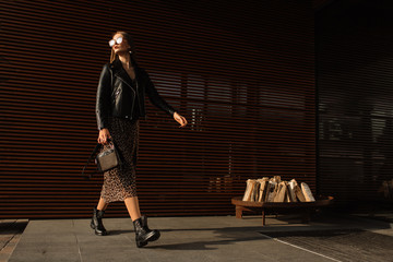 Street fashion. Beautiful young woman in sunglasses. glamorous, model gait. Urban fashion. - 307025462
