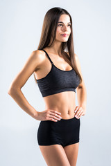 Fototapeta premium Fitness young woman standing isolated on gray background