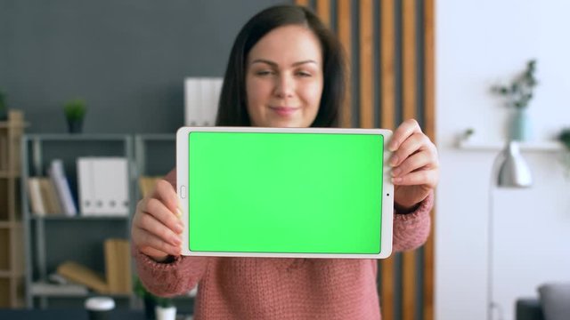 Young Ukrainian Woman Stay in Modern Office or Living Room and Hold Tablet with Green  Screen. Can be Used For Commercial or other Product Ads. 4k.
