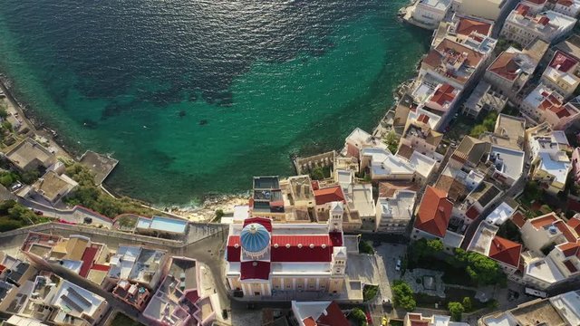 Aerial drone video of picturesque district built by the sea of Vaporia in main town of Syros or Siros island Ermoupolis and famous church of Agios Nikolaos, Cyclades, Greece