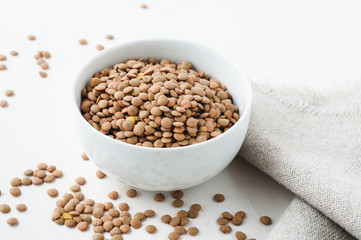 Dried green lentils on a white plaster textured background