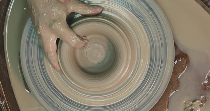 Woman hands on pottery wheel, potter at work. Craftsman artist shapes pot