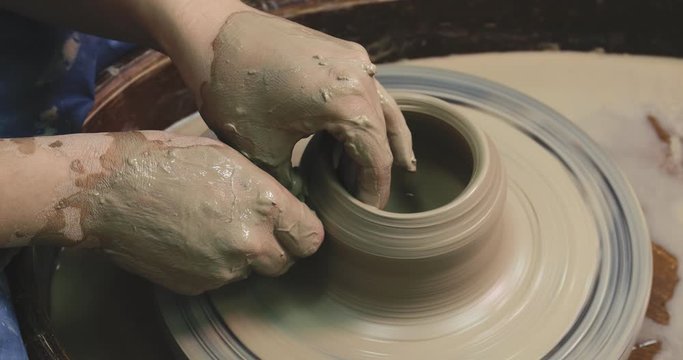 Woman hands on pottery wheel, potter at work. Craftsman artist shapes pot