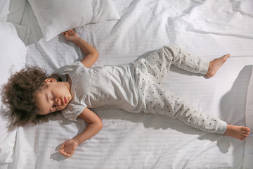 Little African-American girl sleeping in bed at night