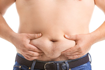 Naklejka premium Overweight man touching his belly against white background, closeup. Weight loss concept