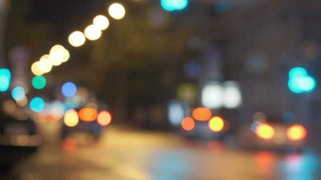 Out of focus night city traffic, rainy roads with colorful light reflexes and reflections on asphalt. Colourful bokeh headlights. Blurry Video for blend mode