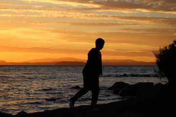 Fototapeta premium silhouette of a man on the beach at sunset