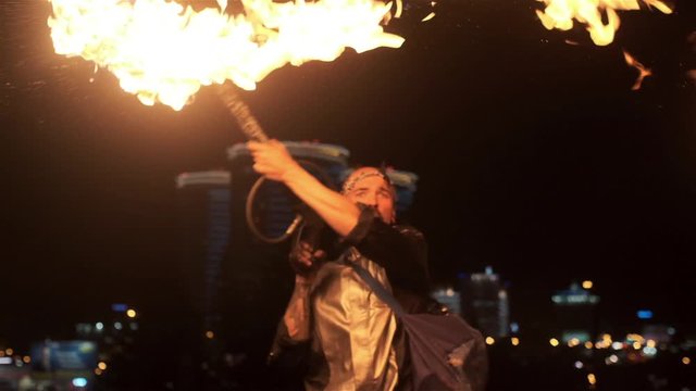 Fire performance with powerful flamethrower. Strong and expressive showman demonstrate dangerous and spectacular tricks with fire gun. Rush and stream of fire, fuel spray. Super slow motion.